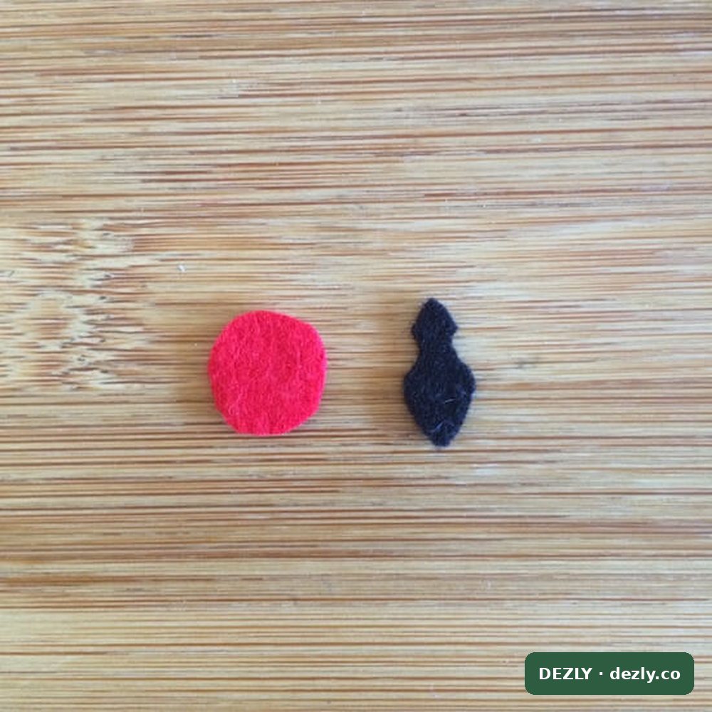 Los dos cuerpos de araña de fieltro recortados: un círculo rojo y una forma negra de ocho