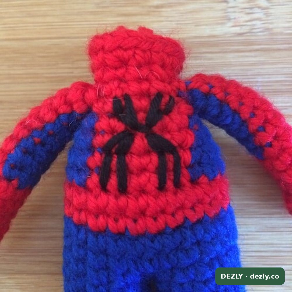 El emblema del pecho terminado, con las patas de la araña bordadas sobre la columna roja